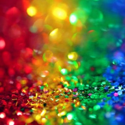 Piles of sequins in the colours of the rainbow flag. Image: Pexels/Sharon McCutcheon